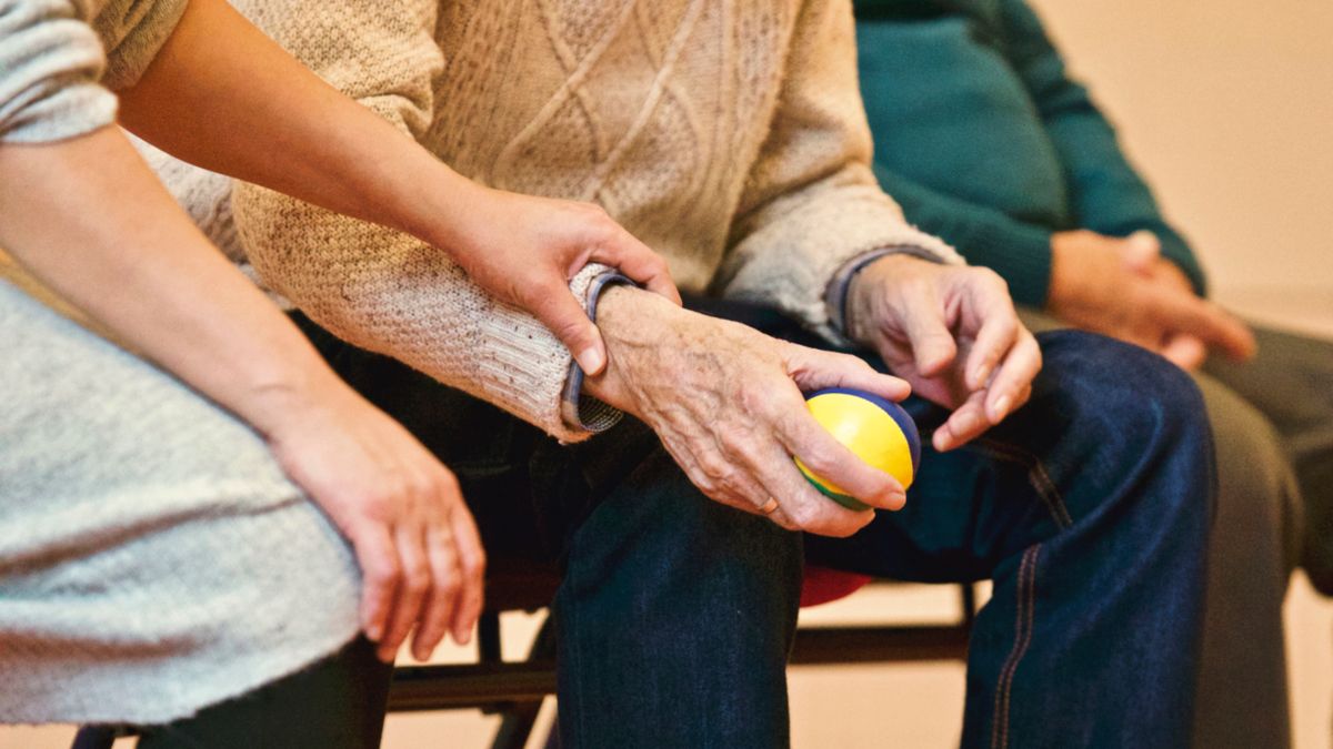 Older adult taking part in a supportive activity with family caregivers